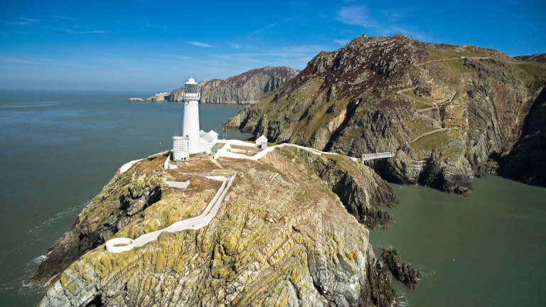 Delwedd o Oleudy Ynys Lawd o’r awyr, ar ben clogwyn.