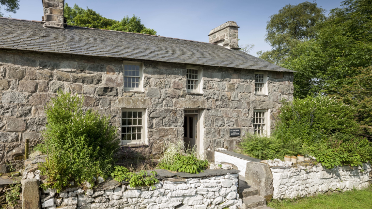 Llun o'r tu allan i hen ffermdy cerrig