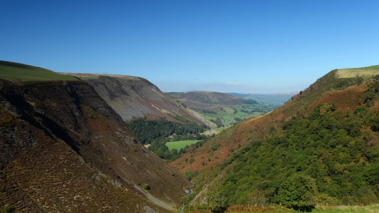 Golygfa o fynyddoedd ac awyr las