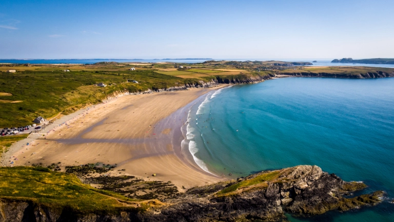 Traeth llydan, tywodlyd a welir oddi uchod.