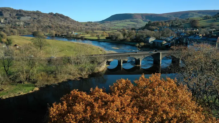 Golygfa o bont ac afon yn lliwiau’r hydref.