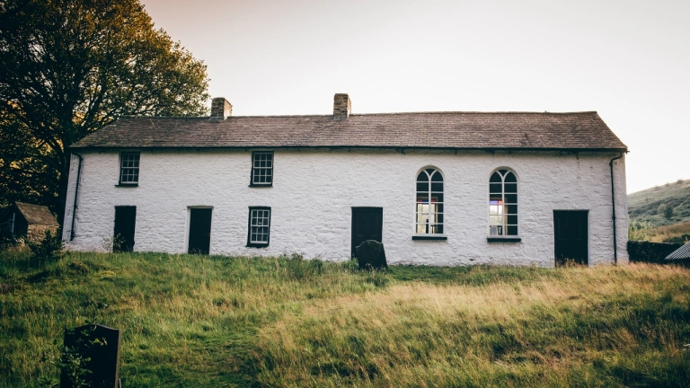 Capel gwyn mewn cae gwyrdd. Mae nifer o ffenestri a dwy ffenestr fwa mawr.