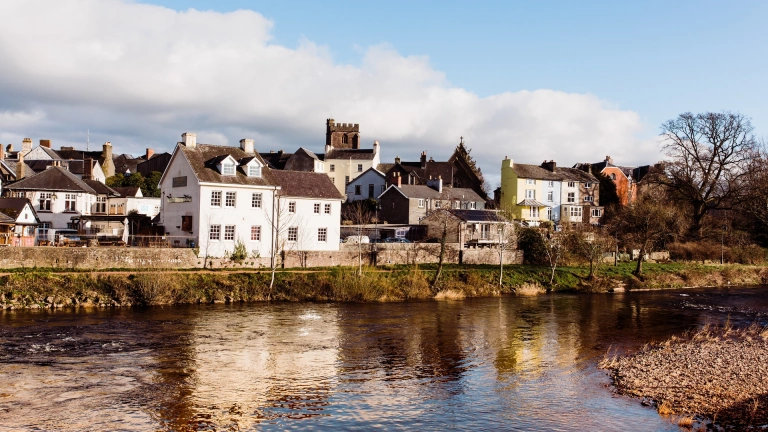 Afon gyda thai ar hyd y lan ac Eglwys Gadeiriol Aberhonddu yn y pellter
