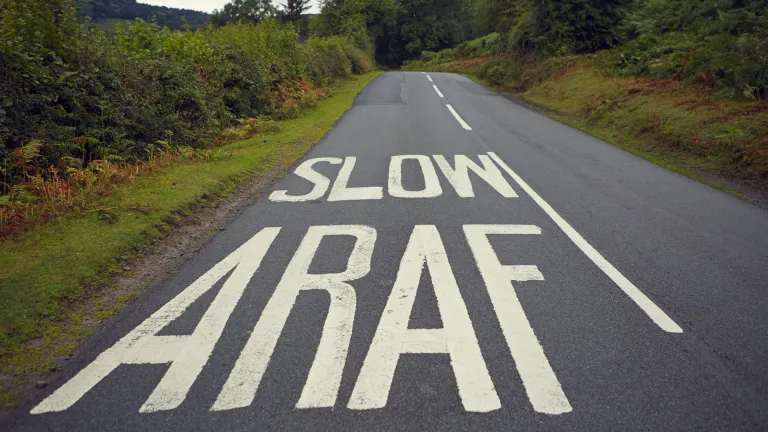Darn o ffordd yr A470 gydag arwydd araf ar y ffordd.