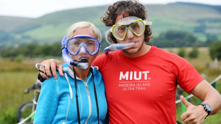 Dyn a menyw yn gwisgo snorcl a gogls