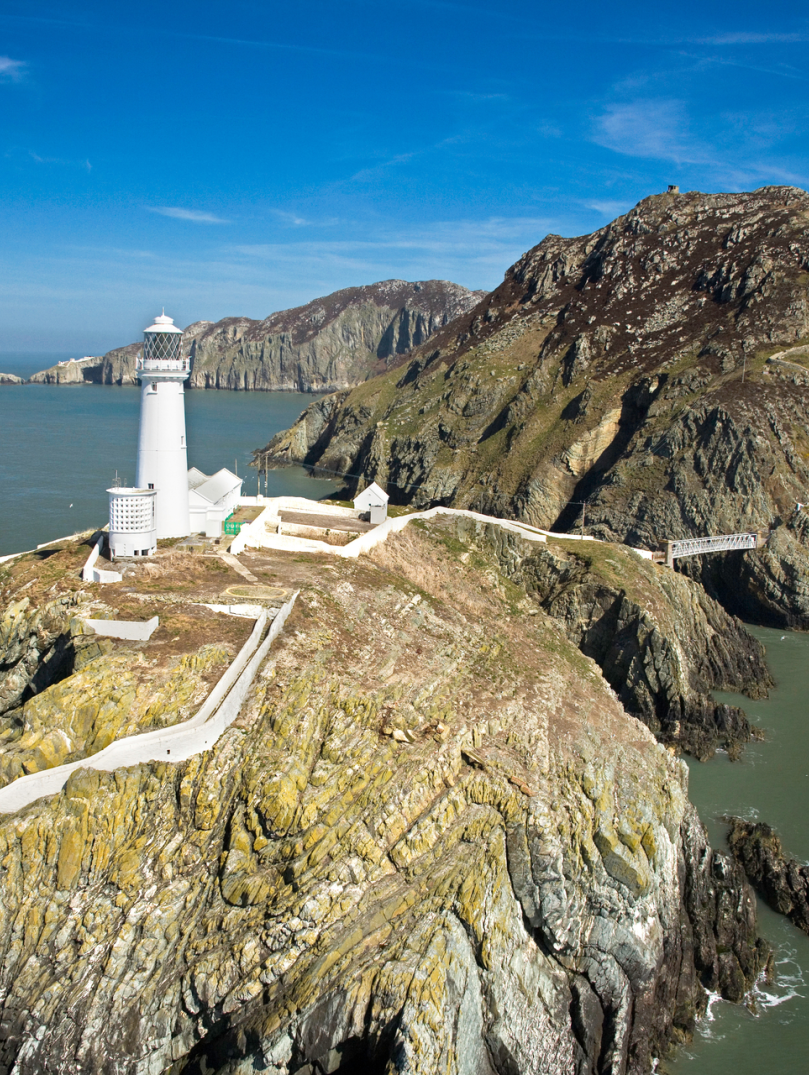 Delwedd o Oleudy Ynys Lawd o’r awyr, ar ben clogwyn.