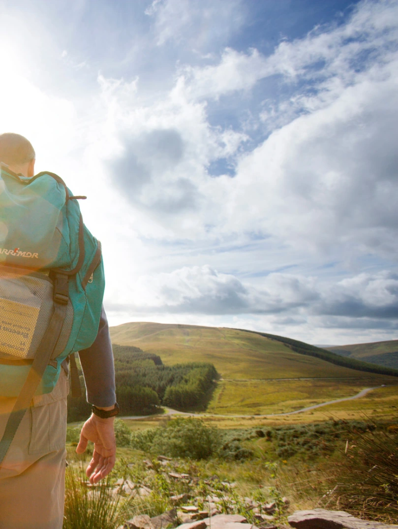 man with a backpack hiking through the Bannau Brycheiniog (Brecon Beacons).