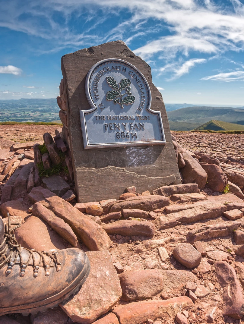 Cerddwr ar gopa Pen y Fan (886m).
