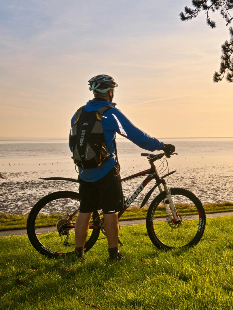 Cyclists on Coast Path at Blackpill at sunrise with Mumbles Head in background