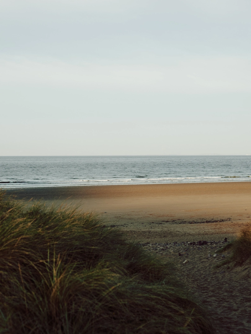 Llun o'r môr, traeth a thwyni tywod