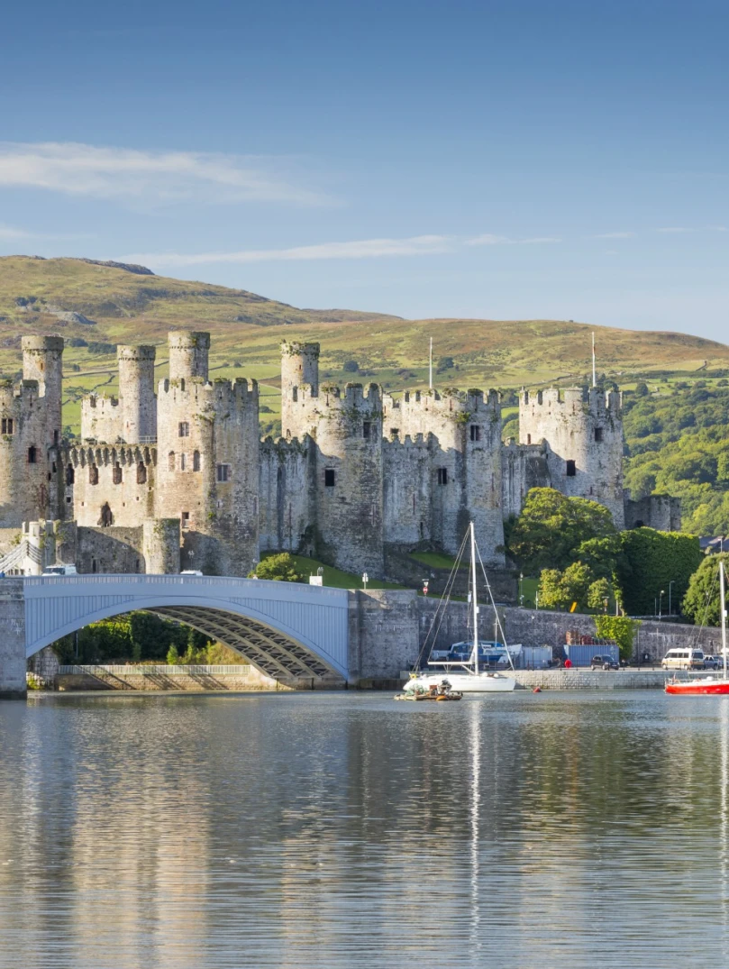 Golygfa yn edrych dros y dŵr tuag at Gastell Conwy