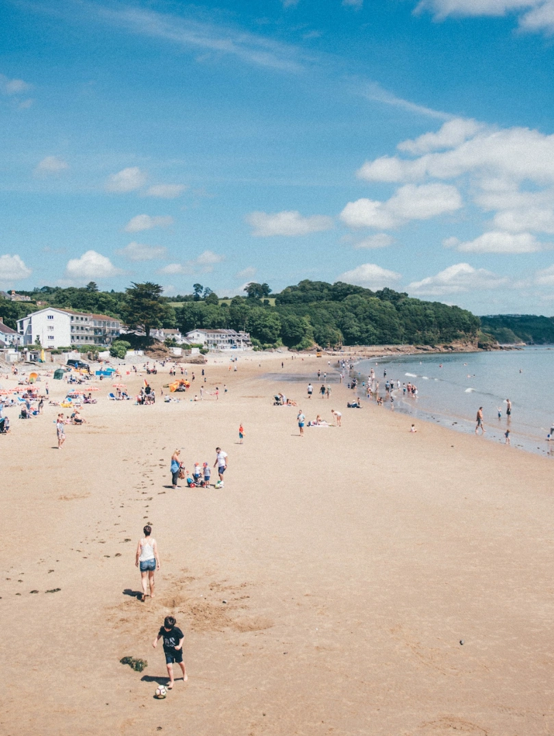 Teuluoedd yn chwarae ar y traeth