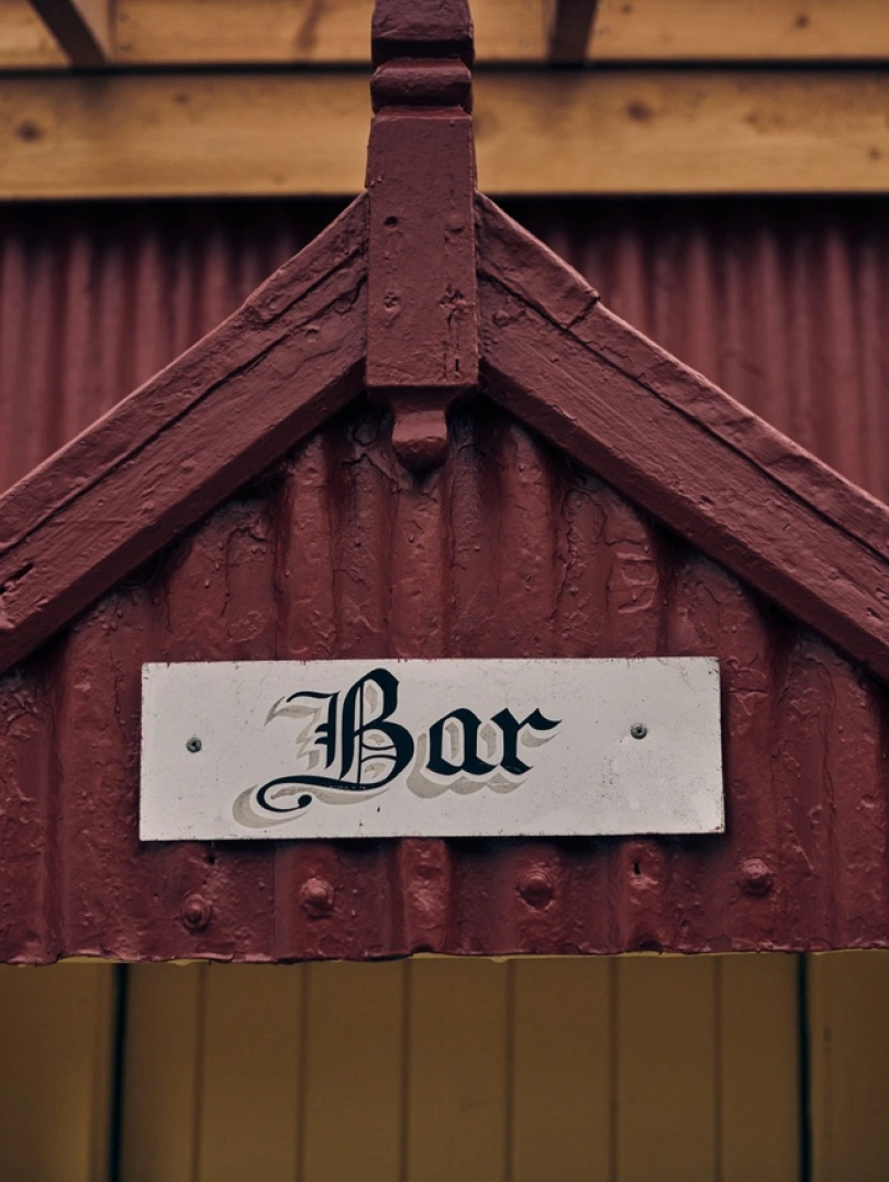 Arwydd Bar ar hen adeilad sinc coch.