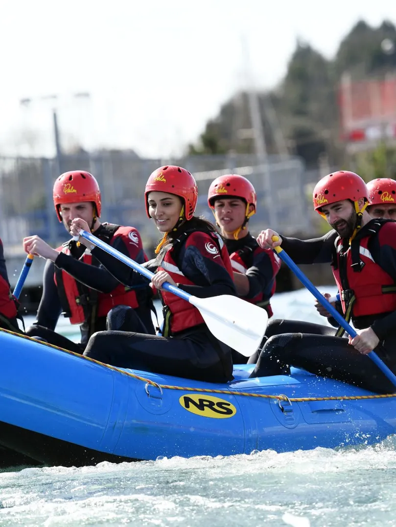 Pobl yn eistedd ar rafft las ar y dŵr