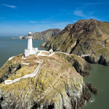 Delwedd o Oleudy Ynys Lawd o’r awyr, ar ben clogwyn. 