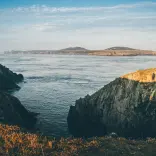 Golygfa niwlog o'r morlin, y môr ac ynys