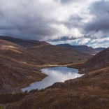 Golygfa o'r llyn wedi'i amgylchynu gan fynyddoedd ar y ddwy ochr ac yn y cefndir