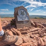 Cerddwr ar gopa Pen y Fan (886m).