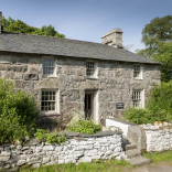 Llun o'r tu allan i hen ffermdy cerrig