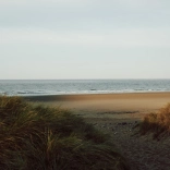 Llun o'r môr, traeth a thwyni tywod