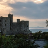 Llun o'r tu allan i'r castell wrth iddi nosi