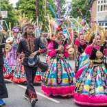 Grŵp o berfformwyr mewn dillad traddodiadol yn gorymdeithio trwy Llangollen