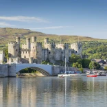 Golygfa yn edrych dros y dŵr tuag at Gastell Conwy