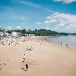 Teuluoedd yn chwarae ar y traeth
