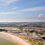 Golygfa yn edrych dros Ynys y Barri gyda awyr las a'r môr