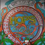 Murlun lliwgar gyda thestun 'We love hops'. 