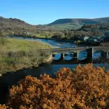 Golygfa o bont ac afon yn lliwiau’r hydref.