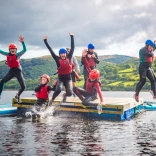 Criw yn neidio oddi ar rafft i fewn i Lyn Tegid.