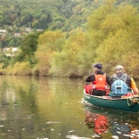 Dau ddyn yn canŵio i lawr afon