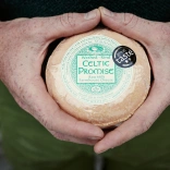 Llun agos o ddwylo yn dal caws Celtic Promise.
