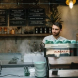 Gwneud coffi ar gyfer y cwsmer tu ôl i'r cownter