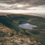 Edrych lawr ar y llyn o ochr y mynydd 