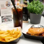 Byrger danteithiol a sglodion euraidd, braf, ynghyd â gwydraid oer o Coke.