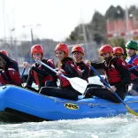 Pobl yn eistedd ar rafft las ar y dŵr