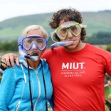 Dyn a menyw yn gwisgo snorcl a gogls