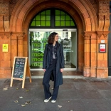 Menyw yn sefyll y tu allan i fynedfa'r oriel gelf sy'n cynnwys gwaith brics addurnedig.