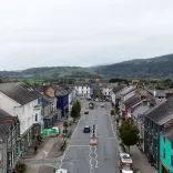 Golygfa awyr o Heol Maengwyn ym Machynlleth, gyda bryniau yn y cefndir.
