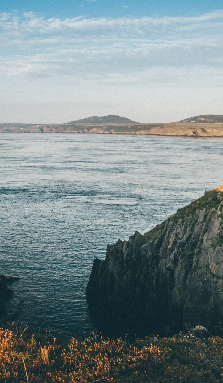 Golygfa niwlog o'r morlin, y môr ac ynys