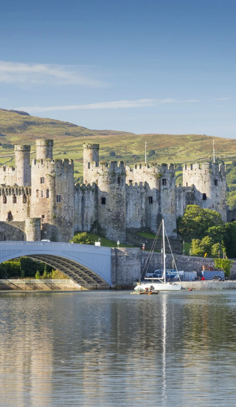 Golygfa yn edrych dros y dŵr tuag at Gastell Conwy