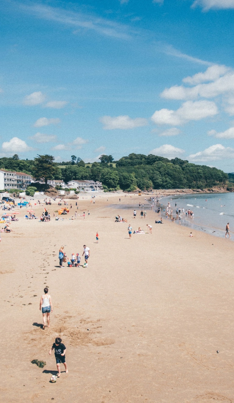 Teuluoedd yn chwarae ar y traeth