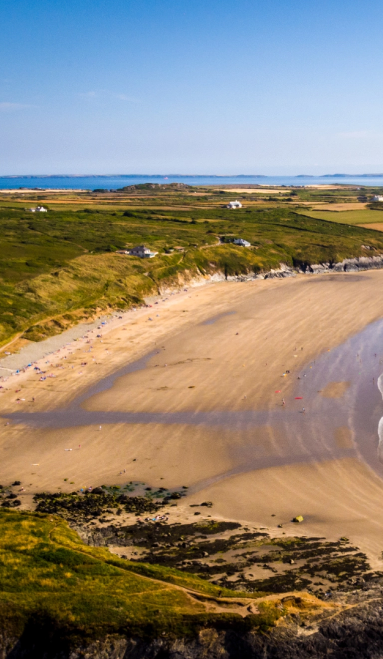 Traeth llydan, tywodlyd a welir oddi uchod.