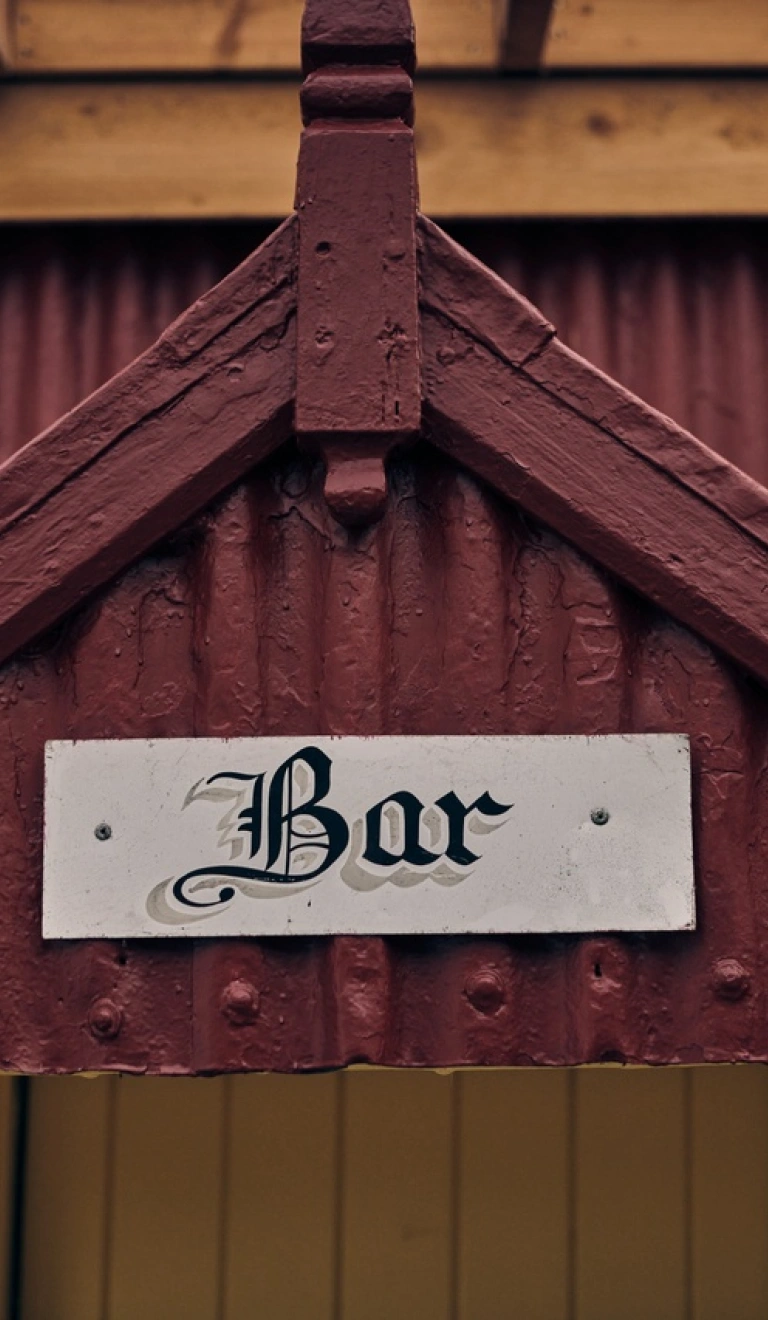 Arwydd Bar ar hen adeilad sinc coch.